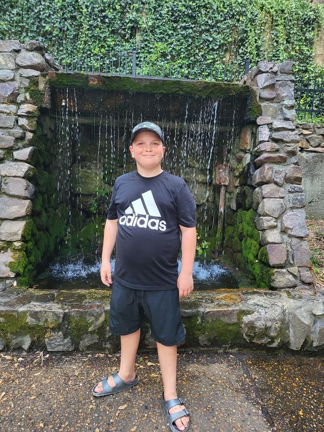 Conor standing in front of a stone waterfall wall