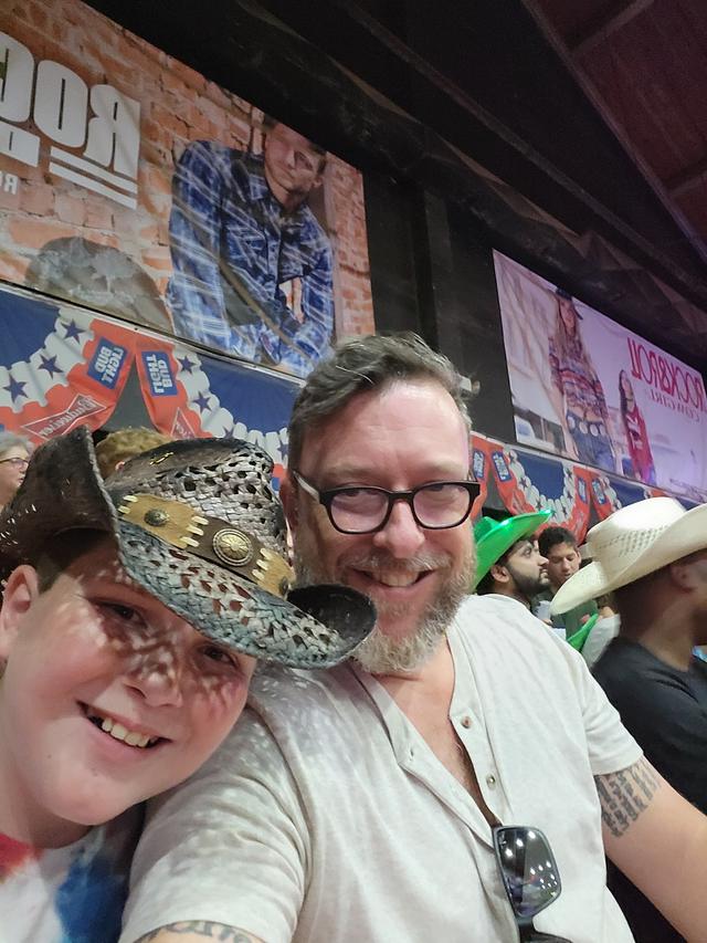 Shane and Conor laughing together in cowboy hats