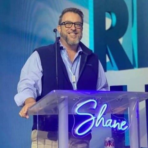 Shane Yerkes speaking from a podium with a microphone at a conference